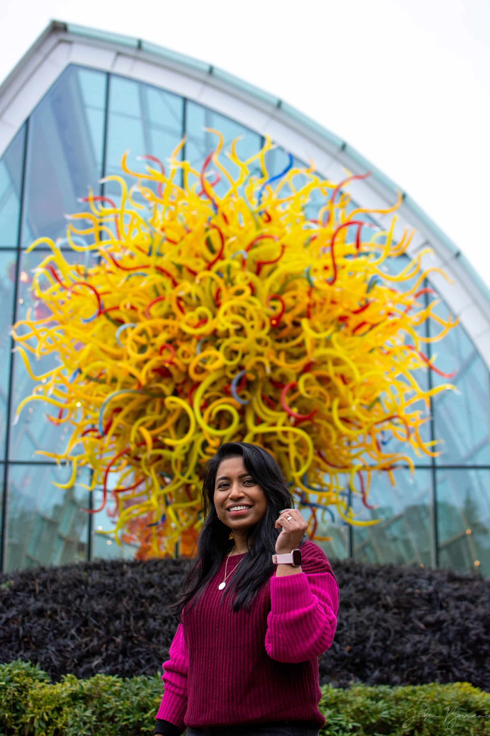 Explorer Tintu Paul poses in front of a Chihuly glass sculpture.