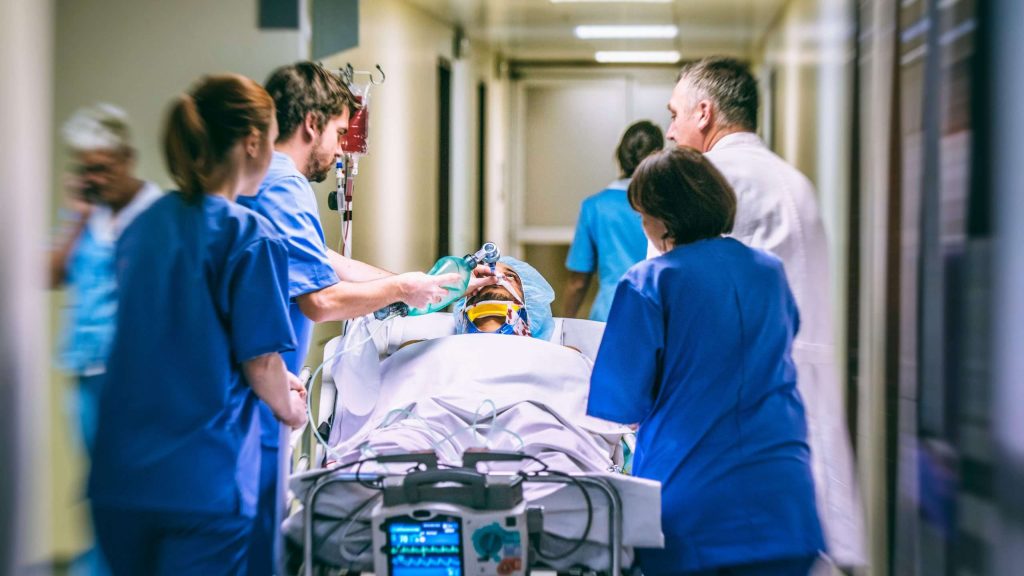 Nurses rushing patient through emergency room