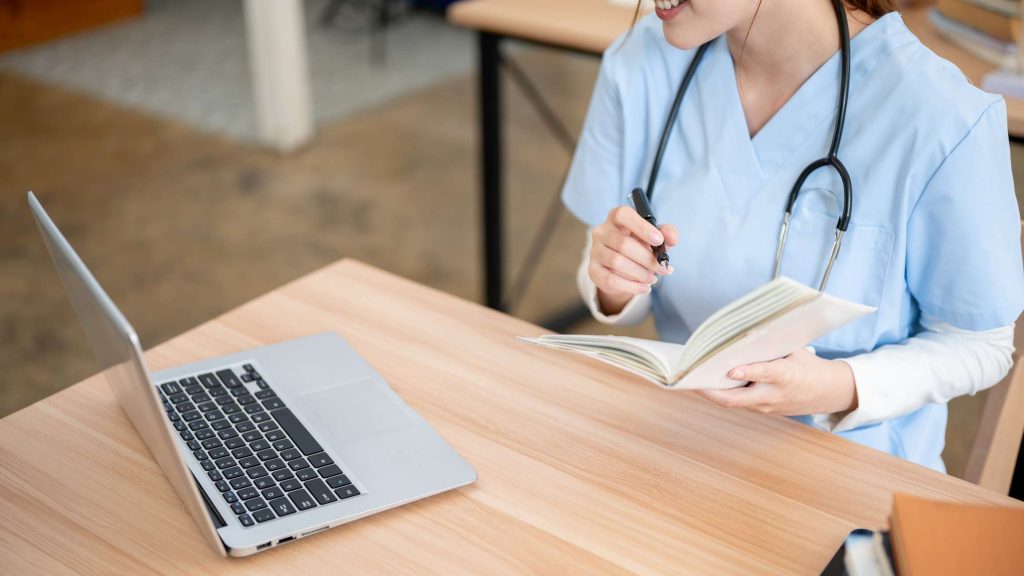 Nurse studying for test on laptop image